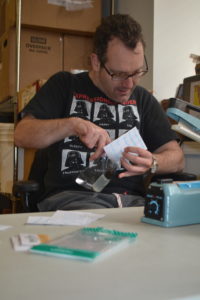Adam Greene assembles favors for the Social Innovations Awards while working at BeechTree. 